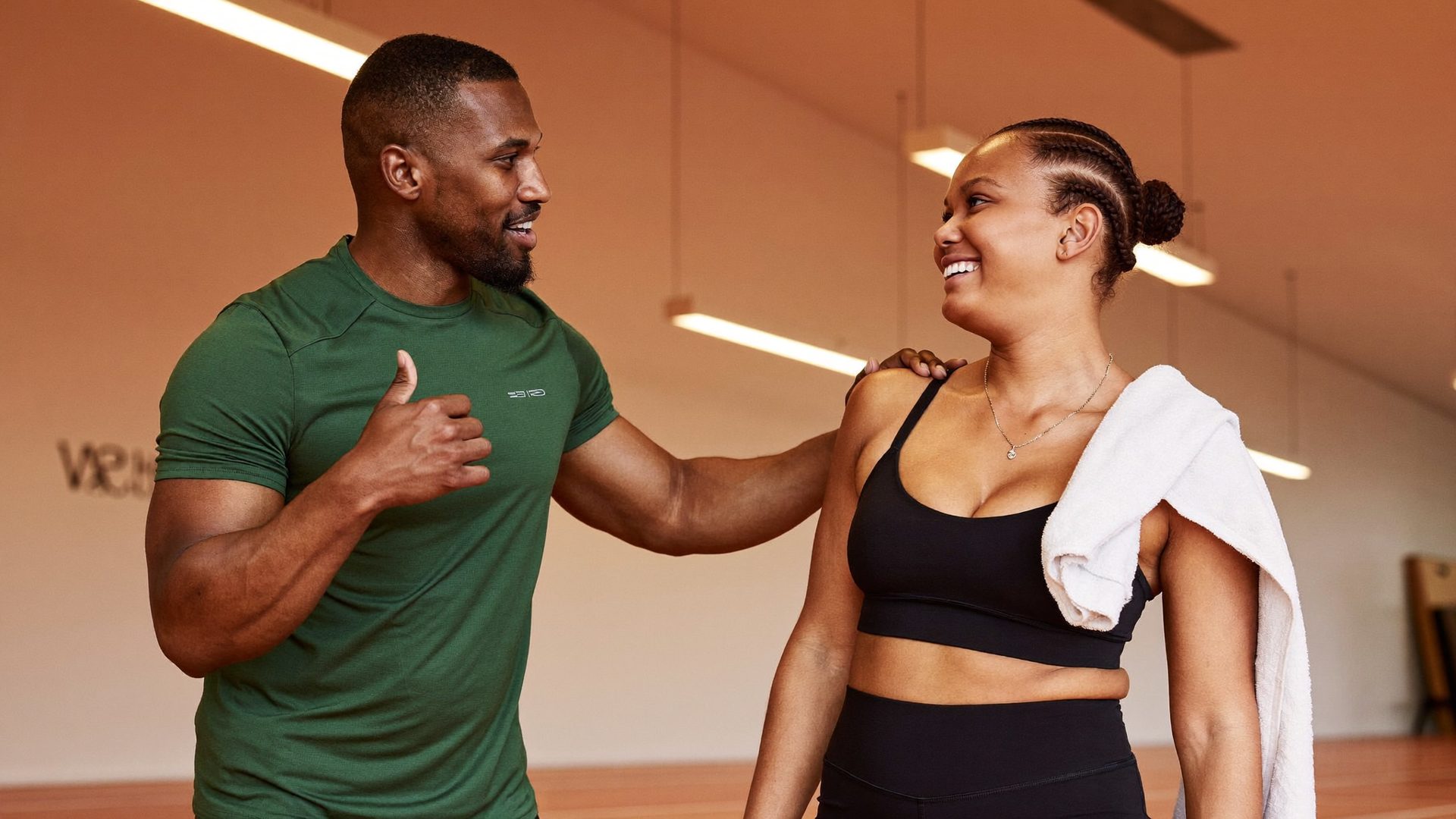 A trainer and member in conversation in a modern gym