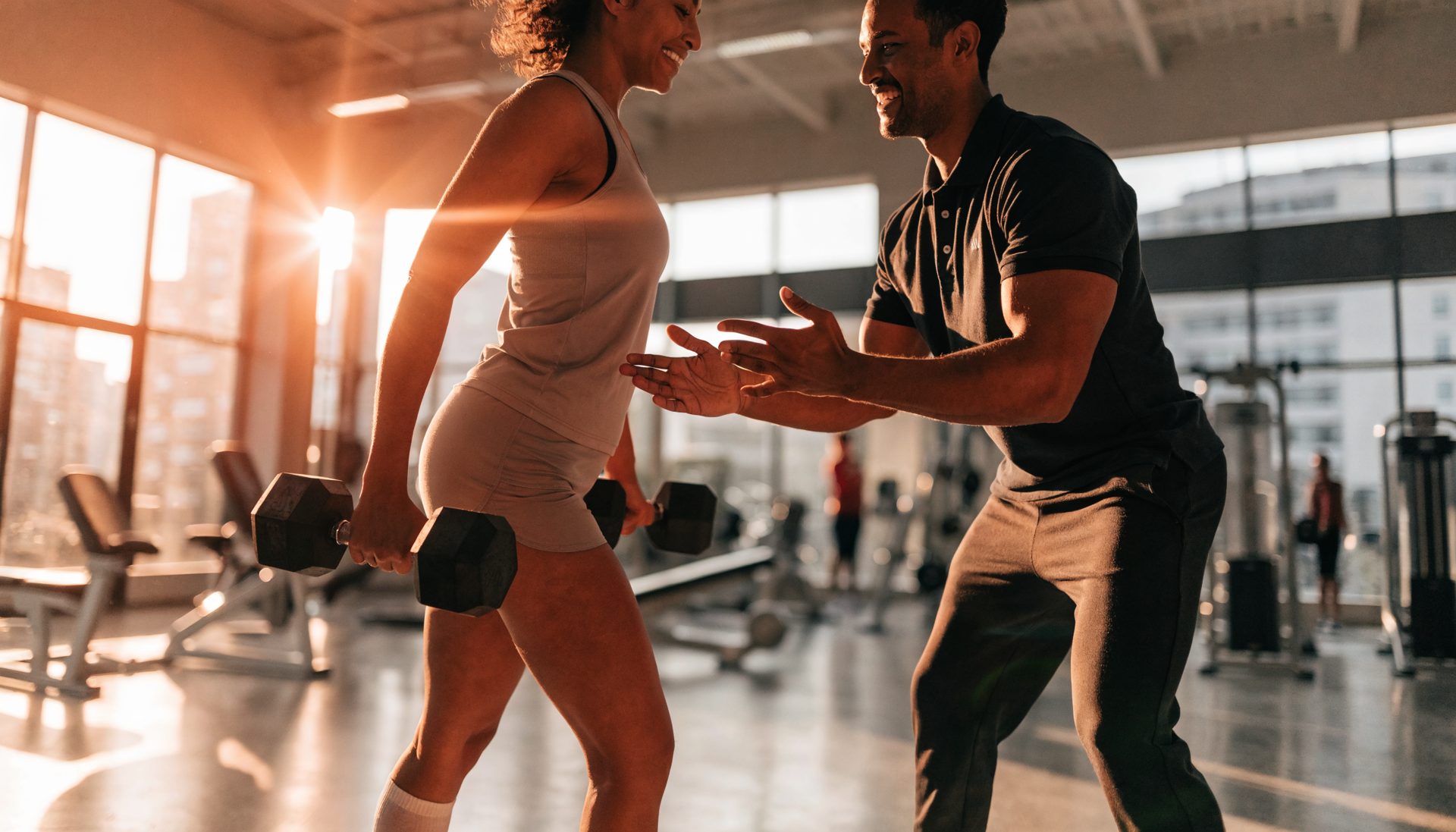 A personal trainer coaching a member in a modern gym